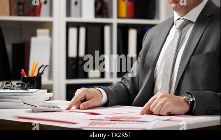 Businessman working and calculating, reads and writes reports. Office employee, table closeup. Business financial accounting concept. Stock Photo