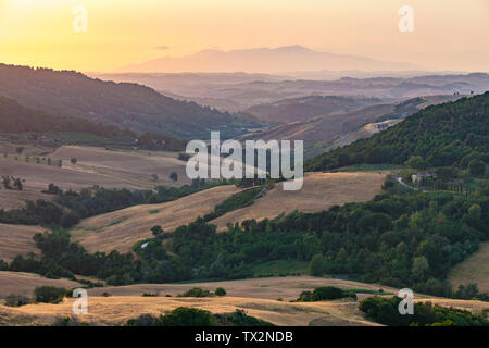Landscape in Tuscany at sunset with hills and mountains and nice warm evening colors, Tuscany, Italy Stock Photo