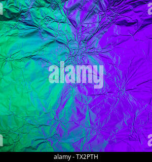 Purple green crumpled background made of illuminated foil. Trendy duotone texture. Stock Photo