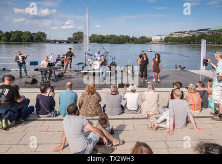 People enjoying an outdoor summer music concert on Jungfernstieg boulevard next to Binnenalster lake, Hamburg, Germany. Stock Photo