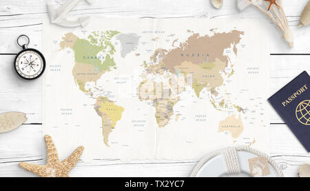 World map, compass, passport and shells. Concept of travel planning. Top view. White wooden desk. Stock Photo