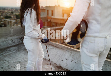 Fencing athletes people practicing outdoor on rooftop Stock Photo