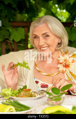 Smiling beautiful senior woman eating healthy breakfast Stock Photo