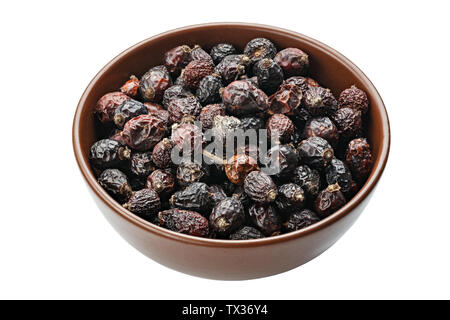 Dried rose hips in wooden bowl. File contains clipping path Stock Photo