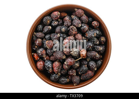 Dried rose hips in wooden bowl. File contains clipping path Stock Photo