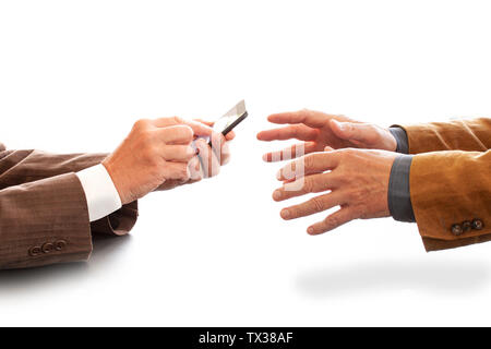 Hands from two businessmen in conversation by a desk. One texting on a cell phone. Negotiating business or a job interview. - Image Stock Photo