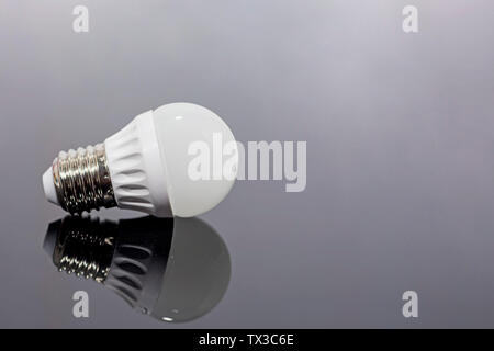 Modern LED lamp on a dark mirror background. Stock Photo