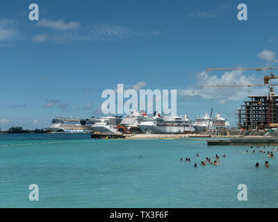 Tourists swimming in sunny ocean with cruise ships in background, Nassau, Bahamas Stock Photo