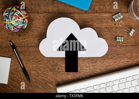 View from above paper cloud with arrow on wooden desk Stock Photo