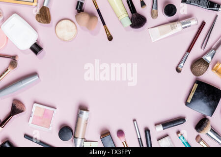 View from above makeup and beauty products on pink background - knolling Stock Photo