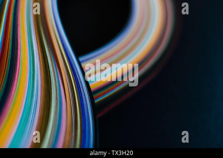 Abstract rainbow paper wave pattern on black background Stock Photo