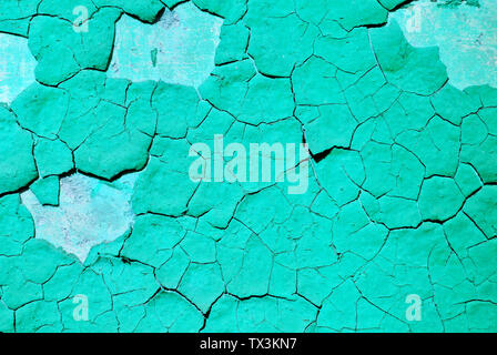 Cracked turquoise paint, plaster surface on wall, grunge horizontal shabby background detail close up Stock Photo
