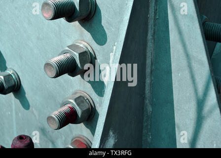 Bolts and nuts on metal surface, top view Stock Photo