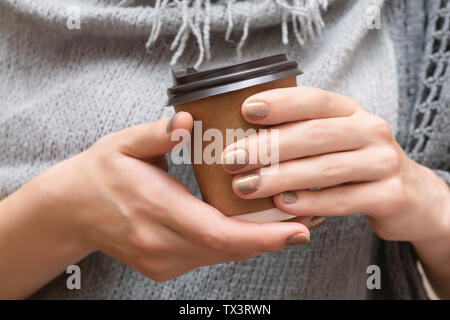 Paper cup with coffee in female hands. Stock Photo