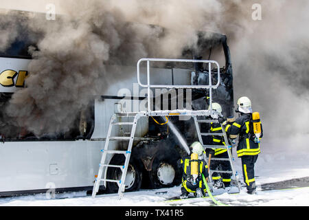 24 June 2019, North Rhine-Westphalia, Castrop-Rauxel: Firefighters extinguish a burning coach. On Autobahn 2, the bus had caught fire with 65 high school students from Herten on board. All passengers were able to leave the bus in the incident between Dortmund and Recklinghausen after the vehicle stopped on the hard shoulder, a police spokesman reported. Photo: Marcel Kusch/dpa Stock Photo