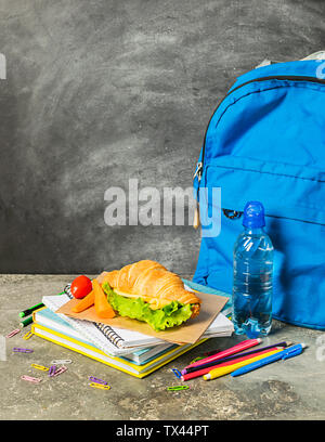 Sandwich training supplies notebooks pens pencils blue backpack against the background of the chalk board. Concept back to school. Selective focus. Co Stock Photo