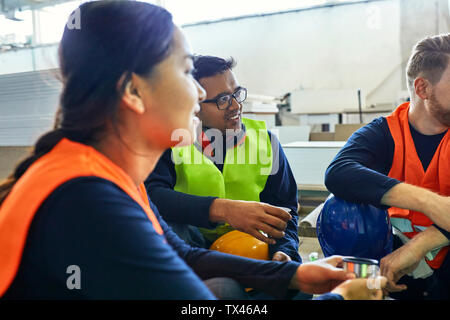 Workers in factory having lunch break together Stock Photo
