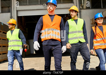 Group of workers walking on factory yard Stock Photo