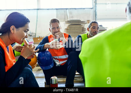 Workers in factory having lunch break together Stock Photo