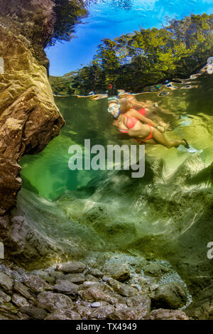 Austria, Salzkammergut, young woman snorkeling in mountain river Weissenbach Stock Photo