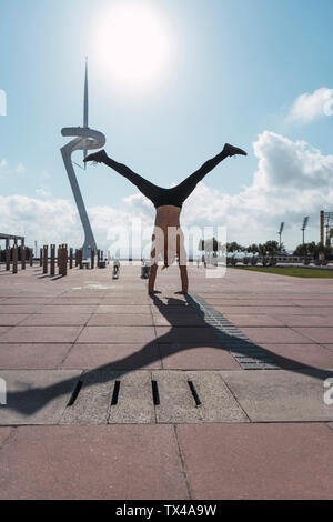 Young man doing a handstand in backlight Stock Photo
