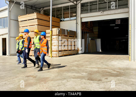 Group of workers walking on factory yard Stock Photo