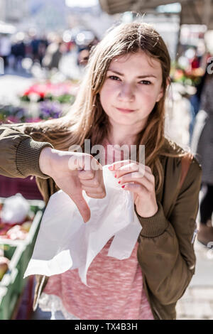 Girl with plastic bag showing thumb down Stock Photo