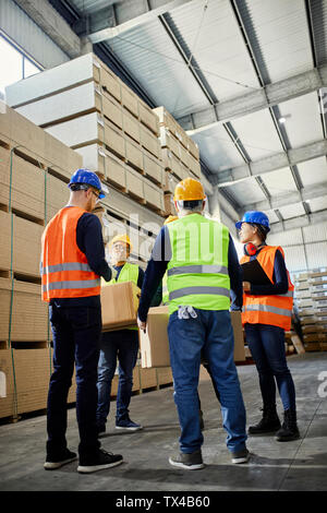Workers talking in factory warehouse Stock Photo