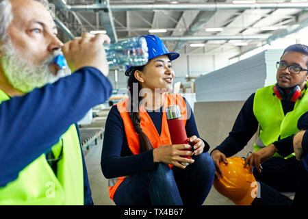 Workers in factory having lunch break together Stock Photo
