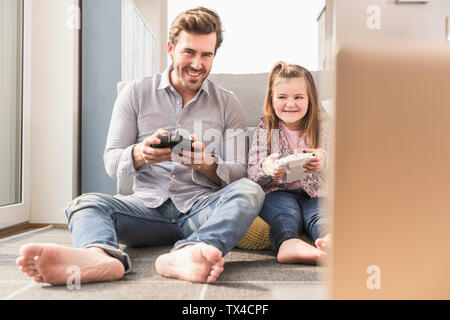 Young man and little girl playing computer game with gaming console Stock Photo