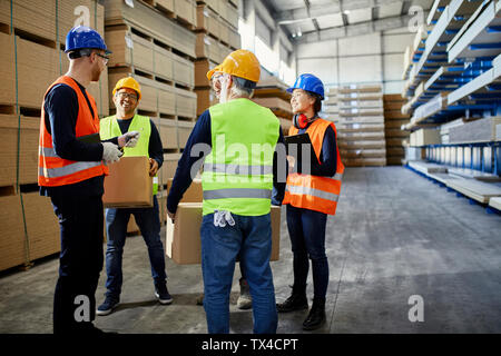 Workers talking in factory warehouse Stock Photo