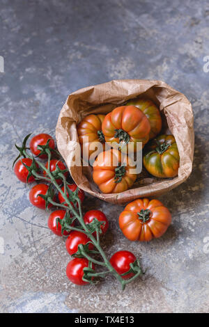 Sardinian beef tomatoes in paper bag and risp of mini plum tomatoes Stock Photo
