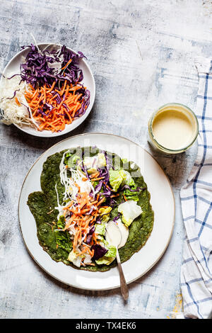 Lettuce wrap with spinach tortillas filled with lettuce, carrots and salad dressing Stock Photo
