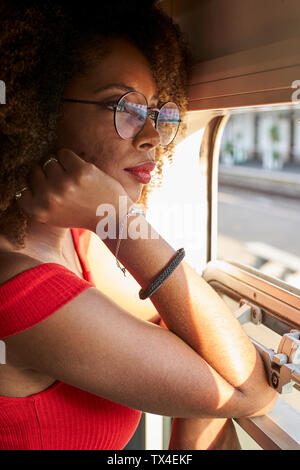 Young woman on a train looking out of window Stock Photo