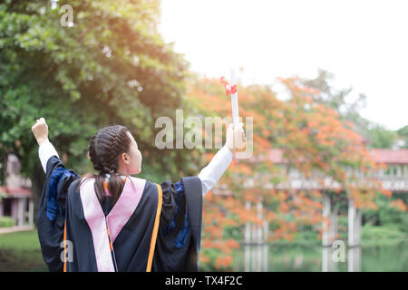 Happy and glad graduated Asian student girl standing and showing hand, congratulations, graduate education success, concept education and finished lea Stock Photo