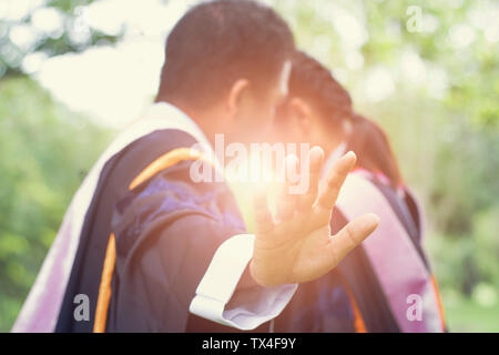 graduated Asian student man standing and showing hand to stop, concept as love in learing and success Stock Photo
