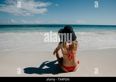 Mexico, Quintana Roo, Tulum, young woman with hat lying on the beach Stock Photo