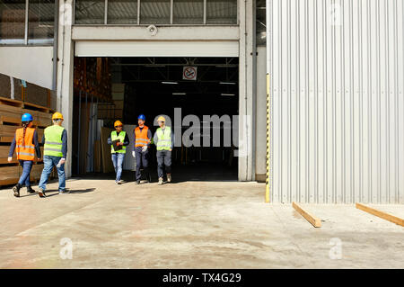 Group of workers walking on factory yard Stock Photo