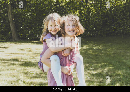 A big sister carrying her small sister, Girl power Stock Photo