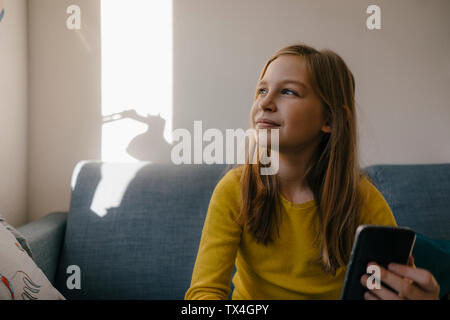 Girl on couch at home with cell phone Stock Photo