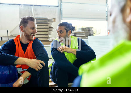 Two happy workers in factory having lunch break Stock Photo