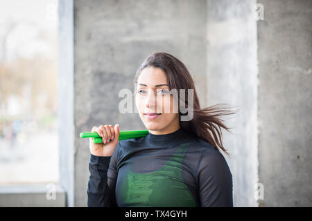 Portrait of smiling young woman holding pound exercise sticks Stock Photo
