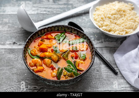 Red curry with sweet potato, yellow and red bell pepper, zucchini, sugar pea, shrimps and rice Stock Photo