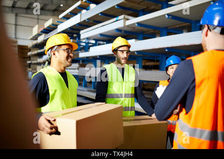 Workers talking in factory warehouse Stock Photo