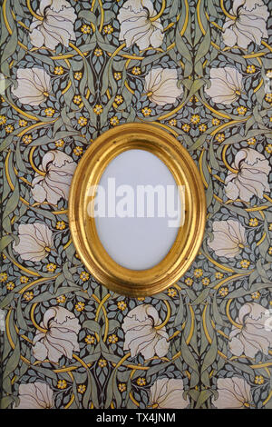 Oval golden picture frame on wallpaper with Art Nouveau floral design Stock Photo