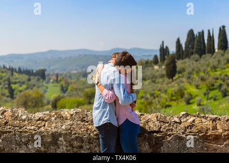 Young couple embracing at wall in Florence, Tuscany, Italy Stock Photo