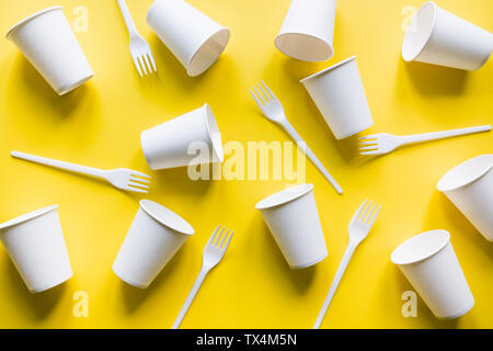 Disposable picnic utensils on yellow. Environment eco friendly discarded plastic garbage for recycle concept.Top view. Flat lay. Pattern. Stock Photo