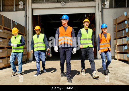 Group of workers walking on factory yard Stock Photo