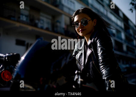 Portrait of content young woman on motorbike Stock Photo