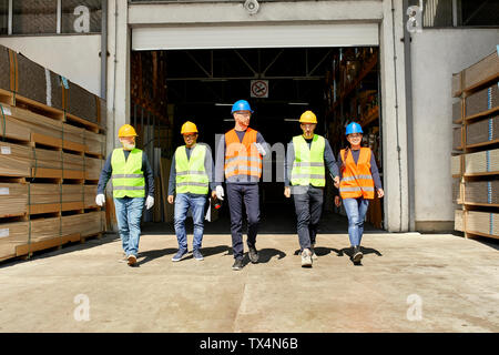 Group of workers walking on factory yard Stock Photo